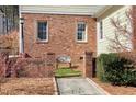 Landscaped walkway to a secluded garden nook with a stone bench and decorative wall at 509 Edgemore Ave, Cary, NC 27519