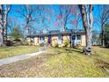 Charming one-story brick home with a walkway leading to the front door and mature trees at 510 Corrida Ave, Durham, NC 27704