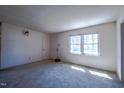 Bright, carpeted living room with a large window and a neutral color palette at 510 Corrida Ave, Durham, NC 27704