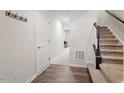 Entryway featuring wood flooring, coat rack, and stairs to the upper level at 515 Autumn Cure Ct, Fuquay Varina, NC 27526