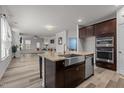 Bright, modern kitchen with stainless steel appliances, center island, and open-concept living area at 5212 Huntley Overlook Dr, Durham, NC 27703