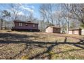 Spacious backyard featuring a home, outbuildings, and mature trees in a tranquil setting at 5315 Cole Mill Rd, Durham, NC 27705