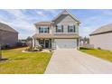 Exterior elevation view of a two-story home featuring manicured lawn and a two car garage at 606 Marian Way, Sanford, NC 27330