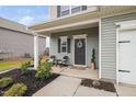 Inviting front porch with seating area and well maintained landscaping at 606 Marian Way, Sanford, NC 27330