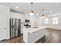 Modern kitchen boasts an island with quartz countertop, stainless steel appliances, and stylish pendant lights at 6434 Astor Elgin St, Raleigh, NC 27616