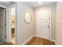 Bright entryway featuring a white door, wooden floors, and convenient access to the bathroom at 700 Bishops Park Dr # 205, Raleigh, NC 27605