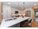Modern kitchen with stainless steel appliances, quartz countertops, and stylish pendant lighting at 700 Bishops Park Dr # 205, Raleigh, NC 27605