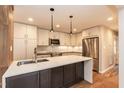 Bright kitchen features white cabinets, stainless steel appliances, and a large island with a sink and seating at 700 Bishops Park Dr # 205, Raleigh, NC 27605