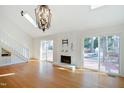 Bright living room with hardwood floors, stone fireplace, skylights, and deck access at 7216 Bluffside Ct, Raleigh, NC 27615