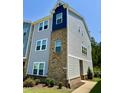 Two-story gray townhouse featuring a mix of brick and siding, enhanced by neat landscaping and a welcoming walkway at 730 Firebrick Drive Dr, Cary, NC 27519