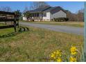 Exterior side view of house featuring a well-maintained lawn and peaceful rural setting at 79 John Horton Rd, Apex, NC 27502