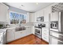 Bright kitchen with stainless steel appliances, white cabinetry, and a window overlooking the outdoors at 8008 Upper Lake Dr, Raleigh, NC 27615