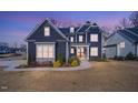 Beautiful two-story home featuring a dark blue exterior and a well-manicured front yard at 8201 Southmoor Hill Trl, Wake Forest, NC 27587