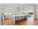 Bright, white kitchen featuring a large island with seating, pendant lighting, and modern appliances at 909 Lake Boone Trl, Raleigh, NC 27607