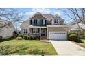Attractive home featuring a blend of stone and siding, a covered porch, and green landscaping at 9117 Cornwell Dr, Wake Forest, NC 27587