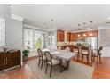Bright dining area featuring a modern table set, large windows, and open layout to the kitchen at 109 Aisling Ct, Cary, NC 27513