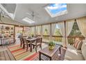 Cozy screened porch featuring skylights, a dining set, and comfortable seating overlooking the pool at 12504 Ribbongrass Ct, Raleigh, NC 27614
