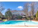 Large swimming pool with an expansive deck, surrounded by mature landscaping and trees at 12504 Ribbongrass Ct, Raleigh, NC 27614