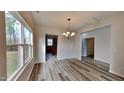 Elegant dining area with hardwood floors and stylish chandelier, adjacent to kitchen and bathed in natural light at 128 Chownings Dr, Sanford, NC 27330