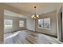 Bright dining room featuring hardwood floors, a stylish chandelier, and multiple windows that flood the space with natural light at 128 Chownings Dr, Sanford, NC 27330