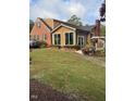 View of the rear exterior featuring an addition with many windows to enjoy the scenery at 132 Lord Ashley Rd, Raleigh, NC 27610