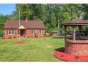 Spacious yard with a brick home, gazebo, and well, perfect for outdoor enjoyment at 132 Lord Ashley Rd, Raleigh, NC 27610