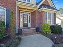 Inviting front door entrance to home featuring red brick steps and manicured landscaping at 132 Mantle Dr, Clayton, NC 27527