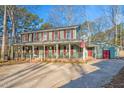 Inviting home featuring a spacious front porch, American flag, and beautiful landscaping at 1408 Hunters Point Way, Cary, NC 27511