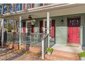 Charming covered front porch with seating area, hanging flower baskets, and inviting red door at 1408 Hunters Point Way, Cary, NC 27511