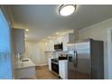 Modern kitchen with stainless steel appliances, white cabinets, and quartz countertops at 1421 Deer Crossing Ct, Henderson, NC 27536