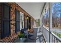 Inviting covered front porch with a chair and side table, perfect for relaxing and enjoying the outdoors at 1500 Allen Ln, Hillsborough, NC 27278