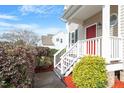 Inviting front entrance with a red door, white railings, and manicured landscaping with red mulch at 153 N Farm Dr, Clayton, NC 27527