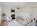 Stylish living room featuring hardwood floors, white trim, a fireplace, and an elegant light fixture at 153 N Farm Dr, Clayton, NC 27527