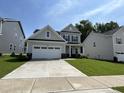 Charming two-story home featuring a well-manicured lawn and a spacious two-car garage at 1560 Bright Coral Trl, Wendell, NC 27591