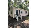 Charming one-story home featuring black shutters, a black door, and light siding nestled among mature trees at 158 Torain St, Hillsborough, NC 27278