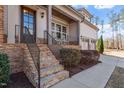 Inviting front porch with stone stairs, metal railings, and space for seating at 1705 Yates Pond Way, Raleigh, NC 27606