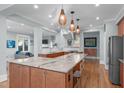 Gourmet kitchen with a large island, granite countertops, stainless steel appliances, and custom lighting at 202 Duncan St, Raleigh, NC 27608