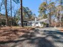 Spacious single-story home with mature trees, a gravel driveway and a chimney on a large lot at 205 Old Greensboro Rd, Chapel Hill, NC 27516