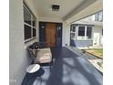 Covered front porch featuring a seating area, a wooden front door, and stylish exterior paint at 205 Old Greensboro Rd, Chapel Hill, NC 27516
