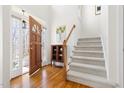 Inviting foyer featuring a staircase, hardwood floors, and a beautifully stained front door allowing natural light at 2325 Old Oak Pl, Hillsborough, NC 27278