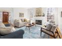Bright living room with fireplace, large windows, and stylish decor, including a patterned rug at 2325 Old Oak Pl, Hillsborough, NC 27278