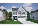 Charming two-story home with stone accents, gray siding, a balcony, and a two-car garage at 247 Meadowbark Bnd # 29, Garner, NC 27529
