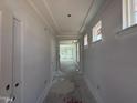 Hallway view featuring white walls, a tray ceiling, and an open doorway at the end of the hall at 251 Meadowbark Bnd # 30, Garner, NC 27529