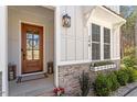 Charming front entrance showcases a wooden door with glass, stone accents, and a well-manicured landscape at 298 Bonterra Way, Chapel Hill, NC 27516