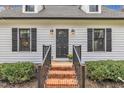 Close up of home entrance showing brick steps, black railings, and decorative lighting at 305 Dickens Rd, Fuquay Varina, NC 27526