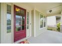 Inviting front entry with a striking red door, sidelights, and a covered porch, creating a warm welcome at 309 Orange Blossom Ct, Wake Forest, NC 27587