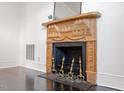A carved, decorative fireplace stands against a white wall with dark hardwood floors at 321 E Lane St, Raleigh, NC 27601