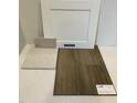Sample board of white kitchen cabinet door, countertop, backsplash, and luxury vinyl plank flooring at 340 Chesapeak Commons St # 139, Garner, NC 27529