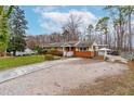 Attractive one-story home with a paved driveway and carport, surrounded by a well-kept lawn and mature trees at 3617 Cranston Rd, Garner, NC 27529