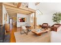 Open floor plan shows living room with exposed beams, fireplace, and comfortable seating with access to kitchen at 380 Wesley Ct, Chapel Hill, NC 27516